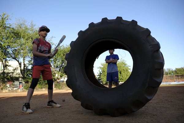 Young baseball players work on their compact swing during a daily training session at the Trinitarios ballpark in Santo Domingo, Dominican Republic, Wednesday, Feb. 5, 2025. (AP Photo/Ricardo Hernandez)