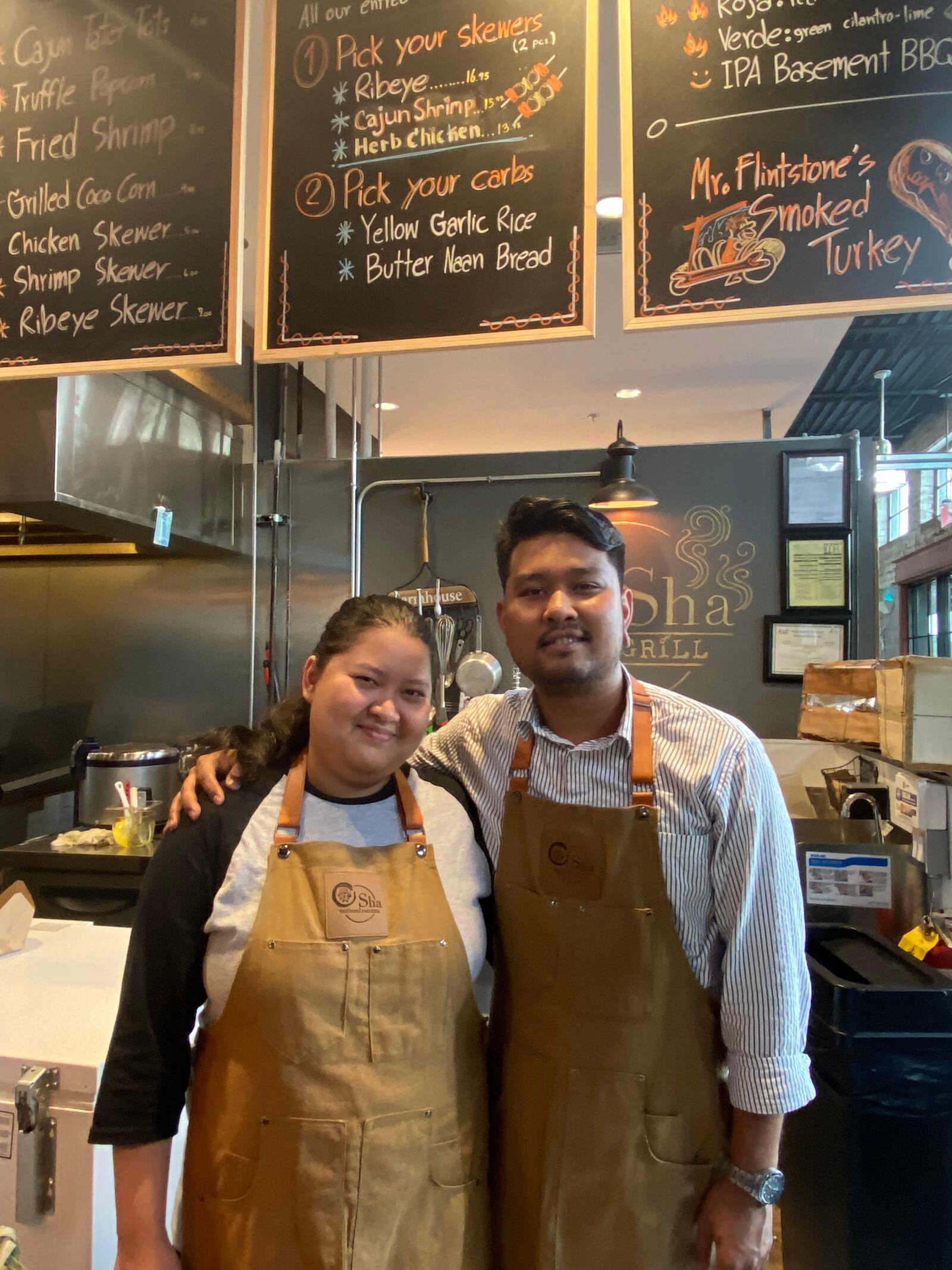 Osha Farm Grill co-owner Pok Aimprig (right) mans the counter with his sister Ploy Aimprig. Osha Farm Grill is one of the recent additions to food stalls at Chattahoochee Food Works. (Ligaya Figueras / ligaya.figueras@ajc.com)