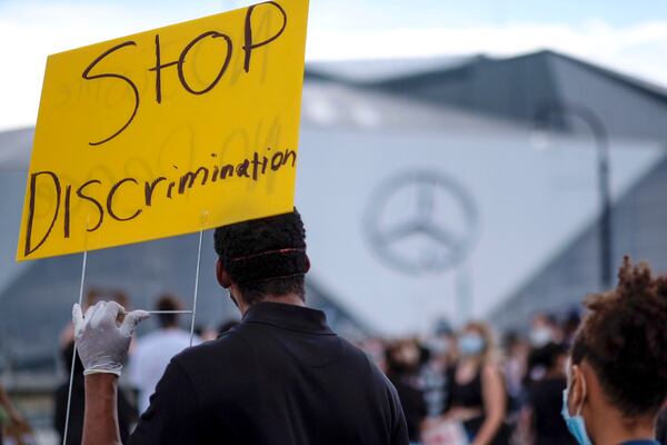 A group of about 100 people remain near Mercedes-Benz Stadium during Friday afternoon's protests.