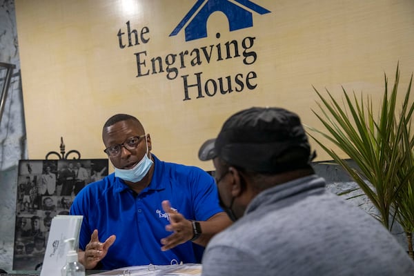 Troy Vincent, founder of The Engraving House, speaks with a client during a consultation in Lithonia, Thursday, October 7, 2021. (Alyssa Pointer/ Alyssa.Pointer@ajc.com)