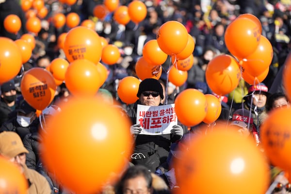 A man holds a sign reading "Arrest Yoon Suk Yeol" during a rally to demand South Korean President Yoon Suk Yeol's impeachment outside the National Assembly in Seoul, South Korea, Saturday, Dec. 14, 2024. (AP Photo/Lee Jin-man)