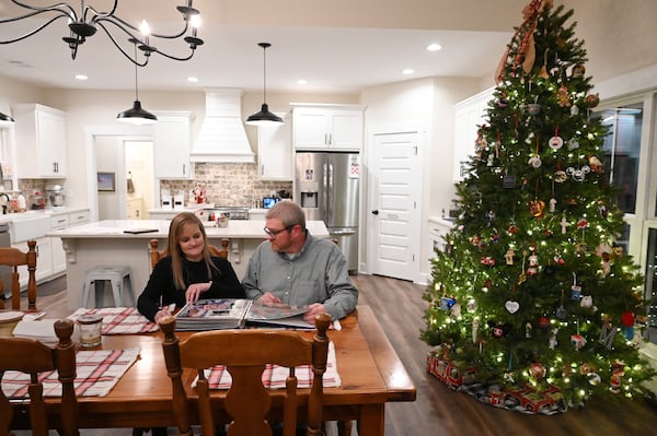 Phil and Amy flip through photos of Grant at their home. One of Amy's hobbies is scrapbooking. Hyosub Shin/AJC