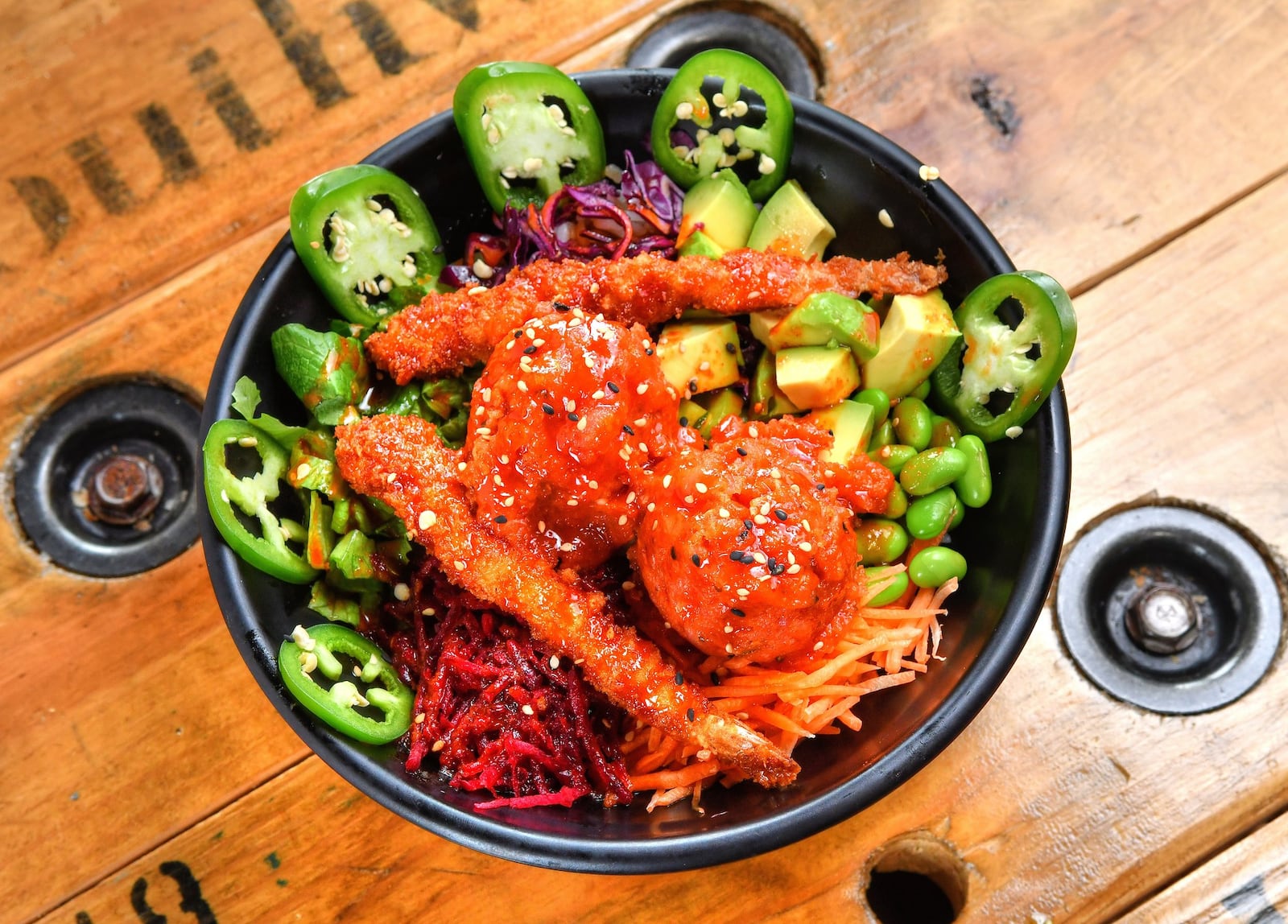 Dynamite Bowl from Poke Burri, with spicy tuna, shrimp tempura, lettuce, carrots, cucumber, cabbage, avocado, edamame, beets, eel sauce, spicy Korean sauce, jalapeno, and pickled ginger. CONTRIBUTED BY CHRIS HUNT PHOTOGRAPHY