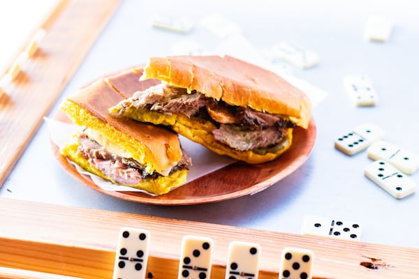 One of the pressed Cuban sandwiches at El Super Pan is the media noche, which includes a crispy chicharron in the center. Henri Hollis/henri.hollis@ajc.com 