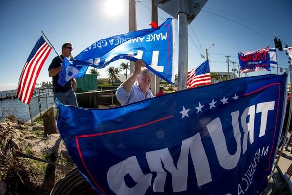 Boynton Beach resident Donald Tarca  Jr. sets up Trump banners at the intersection of Southern Blvd. and Flagler Dr. while waiting for President Donald Trump's motorcade to pass by on the the way to Mar-A-Lago December 31, 2017. Tarca and about 15 or so supporters came out to wave at the President each day during his Christmas vacation in Palm Beach, and on December 30 the President sent vans to pick them up and bring them to Mar-A-Lago for a visit. (Photo: Damon Higgins / The Palm Beach Post)