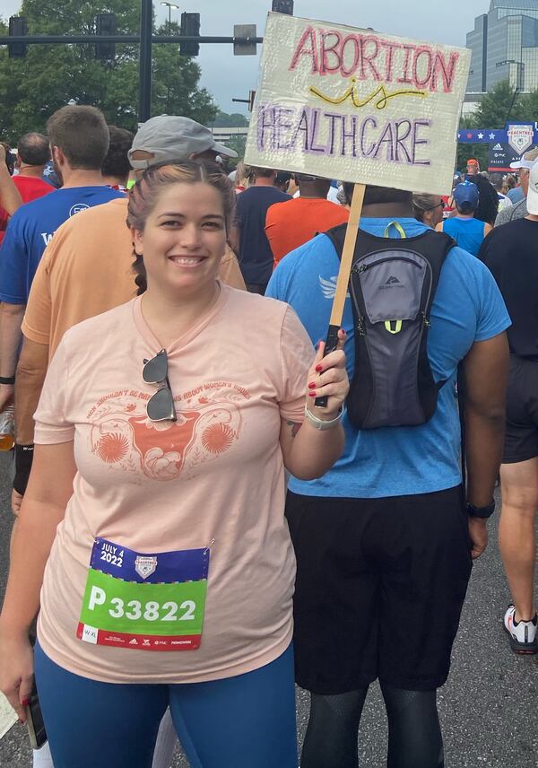 Janna Trujillo of Marietta at the Peachtree Road Race in Atlanta, Georgia on July 4, 2022. A supporter of abortion rights who has had an abortion, she said her sign drew both praise and taunts.