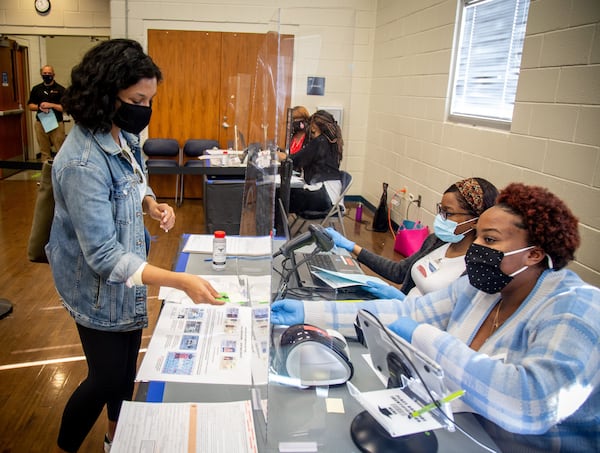 Khyati Sehgal gets her paperwork before casting her vote in Gwinnett on October 23, 2020.  STEVE SCHAEFER / SPECIAL TO THE AJC 