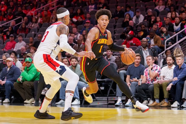 Atlanta Hawks forward Jalen Johnson (1) drives the baseline while guarded by Washington Wizards forward Kyle Kuzma, left, during the first half of an Emirates NBA Cup basketball game, Friday, Nov. 15, 2024, in Atlanta. (AP Photo/Jason Allen)