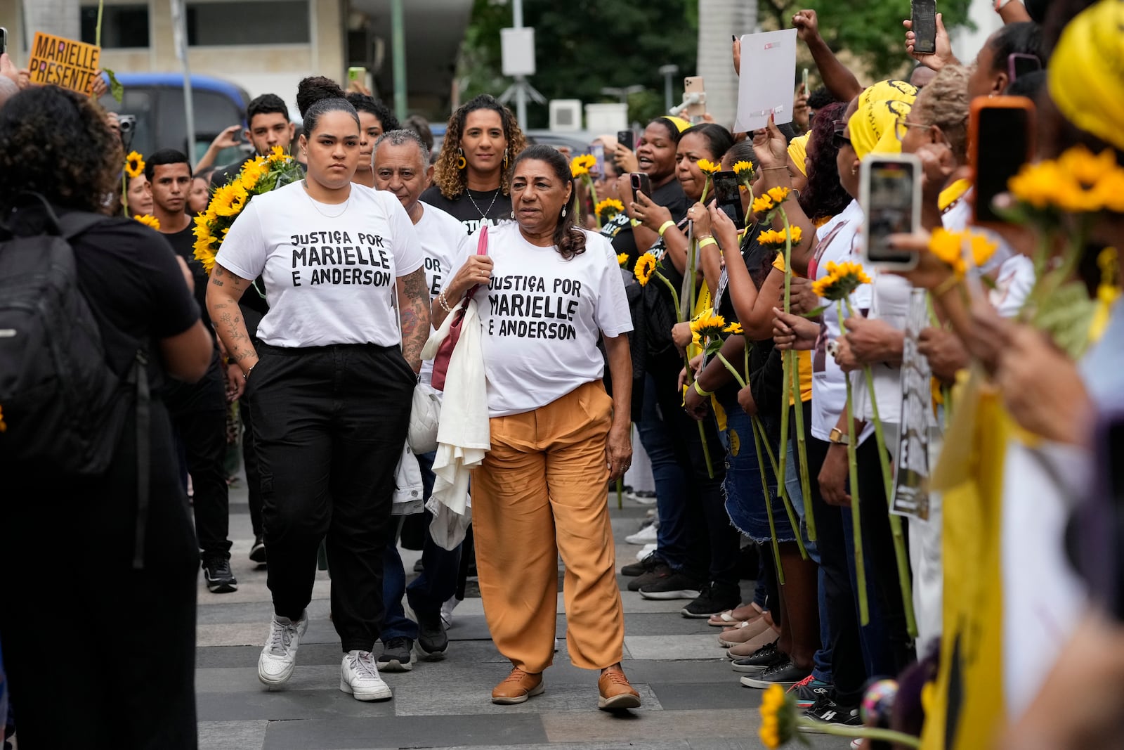 Mother of slain councilwoman Marielle Franco, Marinete Silva, right center, and Luyara Santos, left center, daughter of slain councilwoman Marielle Franco, accompanied by other family members, arrive to follow the trial of former city councilwoman Marielle Franco's alleged killers, in Rio de Janeiro, Brazil, Wednesday, Oct. 30, 2024. (AP Photo/Silvia Izquierdo)