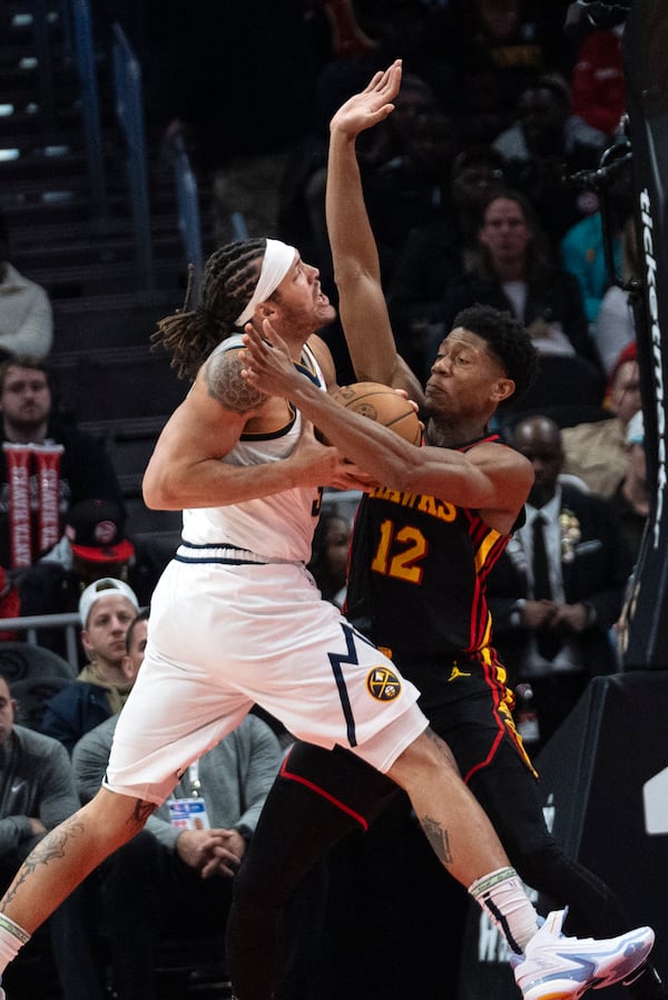 Denver Nuggets forward Aaron Gordon (32) drives against Atlanta Hawks forward De'Andre Hunter (12) during the first half of an NBA basketball game on Sunday, Dec. 8, 2024, in Atlanta. (AP Photo/John Bazemore)