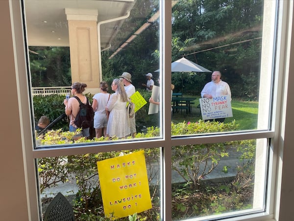 Opponents of Fulton County Schools' mask mandate protest outside a board meeting on Thursday, Aug. 12, 2021. VANESSA McCRAY/AJC