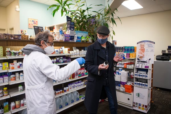 Dec. 22, 2022: Pharmacist Ira Katz helps a customer at Little Five Points Pharmacy. Katz distributes Paxlovid, a COVID-19 treatment medication, to those with a prescription. Public health experts say that Paxlovid is still highly effective at preventing severe illness but that it remains under-prescribed. (Christina Matacotta for The Atlanta Journal-Constitution)