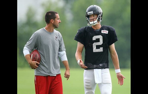 Falcons offensive coordinator Kyle Shanahan confers with quarterback Matt Ryan during team practice Tuesday in Flowery Branch. Curtis Compton/www.ajc.com