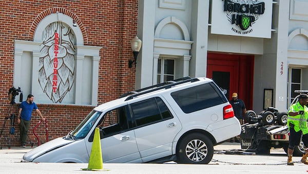 A white SUV fell into a sinkhole in Midtown Atlanta on Tuesday, June 27, 2023.