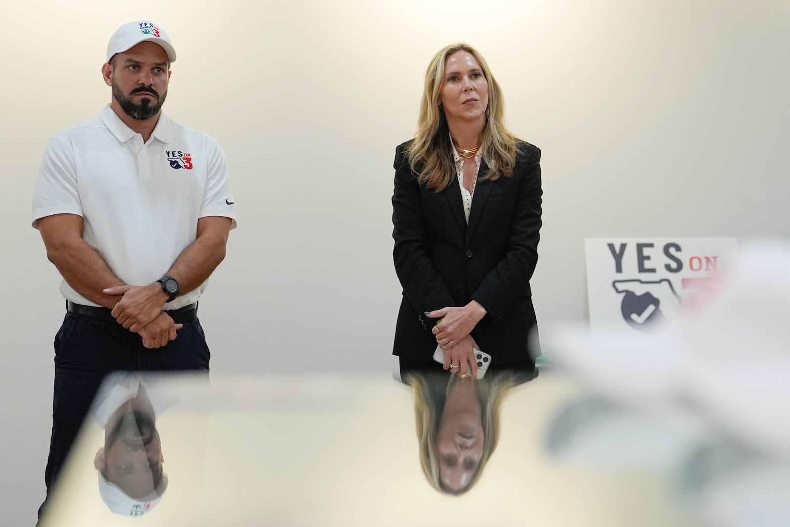 Trulieve CEO Kim Rivers, center, is reflected in a display case while participating in a discussion on the medical marijuana company's safety standards at an event in support of Amendment 3, which would legalize the recreational use of pot in Florida, Wednesday, Oct. 23, 2024, at a Trulieve medical cannabis dispensary in Hallendale Beach, Fla. (AP Photo/Rebecca Blackwell)