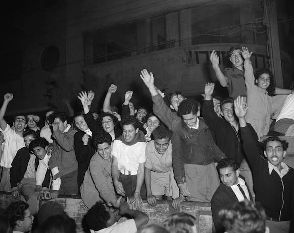 FILE - Jewish people wave and cheer as they gather in the streets of Tel Aviv after radio broadcasts announce that the United Nations plans for the partition of Palestine and the new Jewish state, Nov. 30, 1947. (AP Photo/Jim Pringle, File)