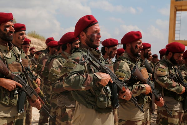 FILE - Turkish-backed Syrian forces stand in formation near the town of Azaz, Syria, on Oct. 7, 2019. (AP Photo, File)