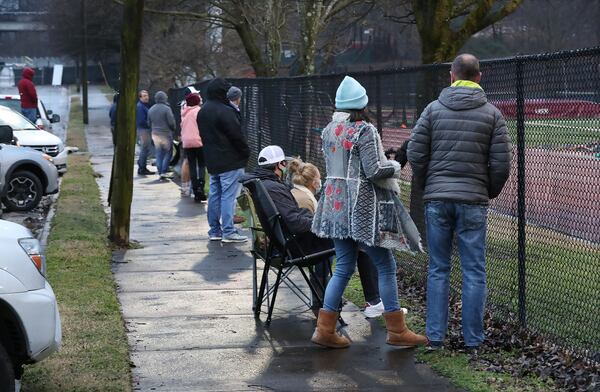 Parents and fans gather to watch the girl’s soccer game from the public sidewalk outside the fence on Chester Avenue at Maynard Jackson High School on Feb. 18, 2021, in Atlanta. Atlanta Public Schools isn’t allowing parents or any spectators to watch athletic events in-person because of COVID-19. (Curtis Compton / Curtis.Compton@ajc.com)