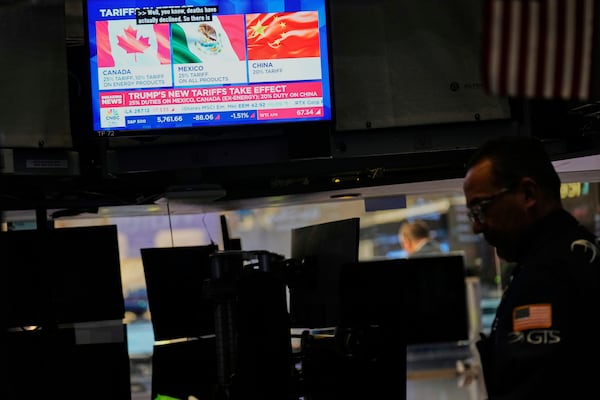 Financial news is displayed as Ppeople work on the floor at the New York Stock Exchange in New York, Tuesday, March 4, 2025. (AP Photo/Seth Wenig)