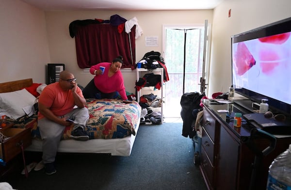 Maria and Tony Fernandez share their bed watching TV in their extended stay hotel room, where they have live their teenage daughter Sussette, in Norcross on Saturday, February 15, 2020. No one knows for sure how many, but thousands of families around metro Atlanta live in extended stay hotels. They are typically working poor, people who make enough money to sort of get by day-to-day, but they don’t make enough to get themselves a stable apartment and certainly not to buy a home. (Hyosub Shin / Hyosub.Shin@ajc.com)