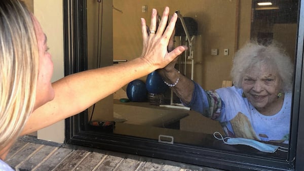 Sally Hoynacki does a window visit with her mom Edna Taylor in July. Taylor lives in a nursing home in Dahlonega. 
CONTRIBUTED