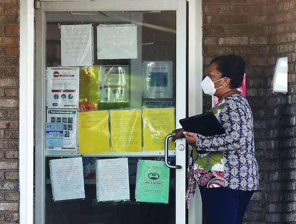 A woman enters the main entrance of Riverside Health Care nursing home. Reports now show that an outbreak in the nursing home that began in early July has ballooned as of Tuesday to 102 residents testing positive and 32 residents dying.  (Curtis Compton / Curtis.Compton@ajc.com)