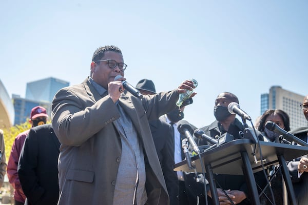 The Rev. Shanan E. Jones, president of the Concerned Black Clergy of Metropolitan Atlanta, pours out a bottle of Coca-Cola as he makes remarks during a press conference with other religious leaders outside of the World of Coca-Cola in downtown Atlanta, Thursday, April 1, 2021.  (Alyssa Pointer / Alyssa.Pointer@ajc.com)