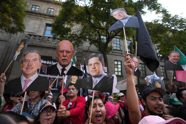 FILE - Justice employees hold up cutouts of Supreme Court justices in a show of support as they discuss a draft ruling that proposes the partial invalidation of the judicial reform approved by Congress, in Mexico City, Nov. 5, 2024. (AP Photo/Fernando Llano, File)