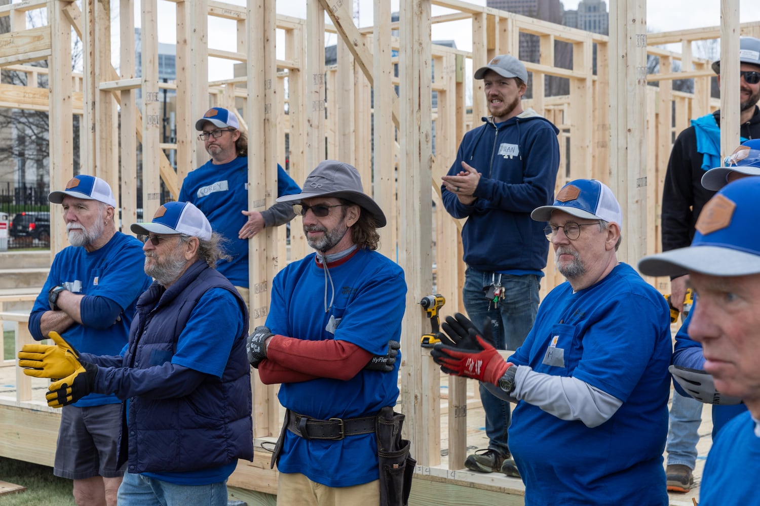 Volunteers with Habitat for Humanity applaud during a speech after building the frame of a home at Liberty Plaza, outside the Capitol, in Atlanta on Wednesday, March 5, 2025. The frame will later be transported and used to house a family. (Arvin Temkar / AJC)