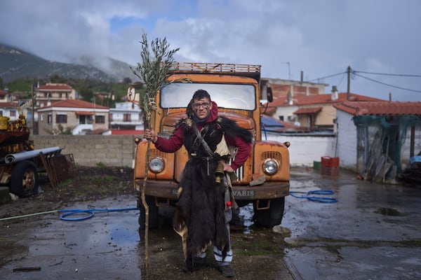 Spyros Bellos, 21, poses for a portrait, dressed in animal skins and heavy bronze bells, as part of carnival celebrations in Distomo, a village in central Greece, on Monday, March 3, 2025. (AP Photo/Petros Giannakouris)