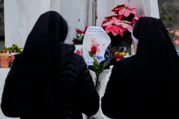 Nuns pray in front of a picture of Pope Francis outside the Agostino Gemelli Polyclinic in Rome, Sunday, Feb. 23, 2025, where the Pontiff has been hospitalized since Feb. 14. (AP Photo/Gregorio Borgia)