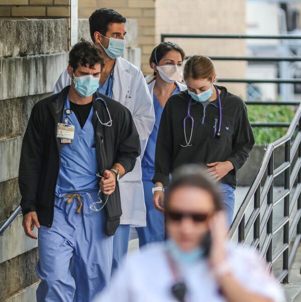 Medical workers move between buildings at Grady Memorial Hospital in downtown Atlanta last week. Already, metro Atlanta hospitals are over capacity, deluged by patients and short of staff. (PHOTO by John Spink / John.Spink@ajc.com)