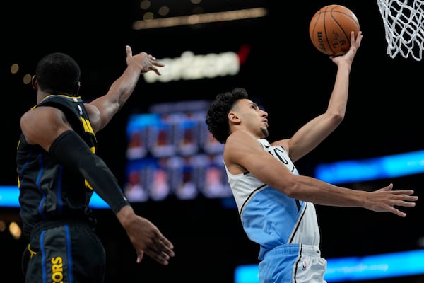 Atlanta Hawks guard Dyson Daniels (5) shoots against Golden State Warriors forward Jonathan Kuminga (00) during the first half of an NBA basketball game, Saturday, March 22, 2025, in Atlanta. (AP Photo/Mike Stewart)