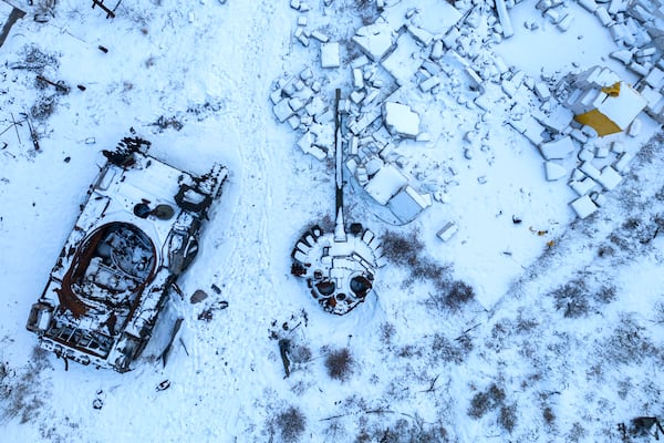 FILE - A destroyed Russian tank, covered in snow, stands in the yard of a private house in the town of Sviatohirsk, Ukraine, Sunday, Feb. 12, 2023. (AP Photo/Evgeniy Maloletka, File)