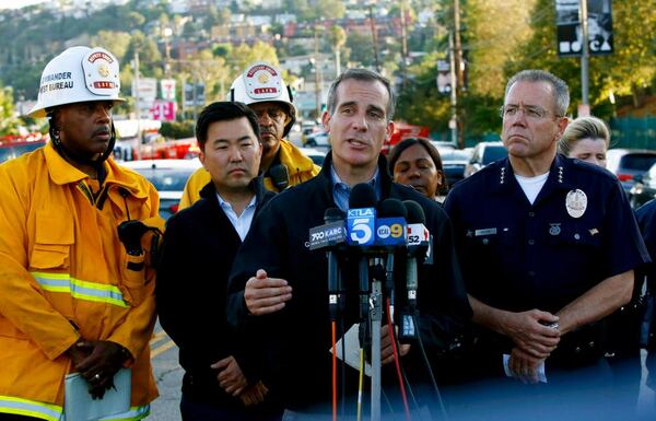 Los Angeles Mayor Eric Garcetti, center, and Police Chief Michel Moore, right, brief the media at a news conference after a gunman held dozens of people hostage inside a Trader Joe's supermarket before surrendering to police in Los Angeles Saturday, July 21, 2018. (AP Photo/Damian Dovarganes)