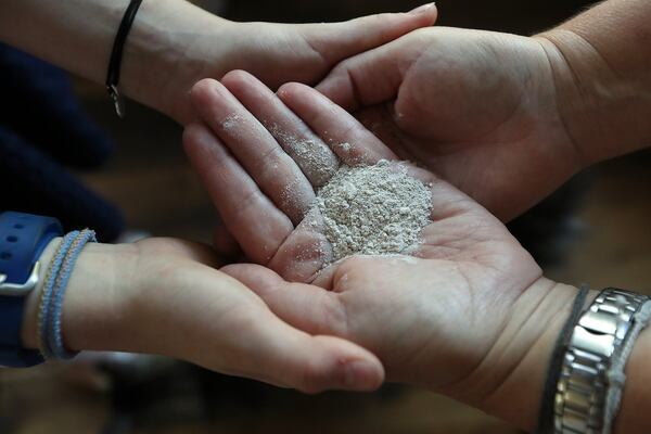 Amanda and daughter Betsy hold some of Jerry’s ashes. CURTIS COMPTON/CCOMPTON@AJC.COM