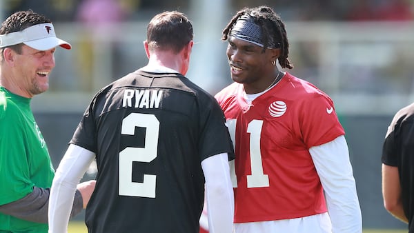 Atlanta Falcons wide receiver Julio Jones gives Matt Ryan a chest bump with quarterbacks coach Greg Knapp looking on the opening day of training camp on Friday, July 27, 2018, in Flowery Branch.