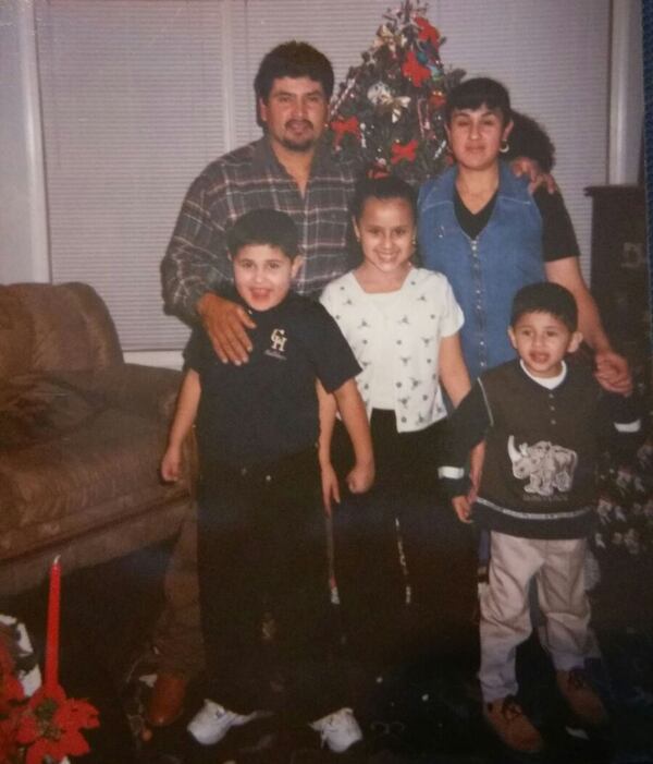 German Botello at age 5 (lower, left) stands in front of his family Christmas tree with his brother (Felipe), sister (Jessica), mother (Estela) and father (Felipe). German was born in Grady Memorial Hospital to two Mexican immigrants. CONTRIBUTED