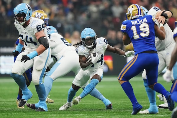 Toronto Argonauts' Deonta McMahon (24) runs against the Winnipeg Blue Bombers during the second half of a CFL football game at the 111th Grey Cup in Vancouver, British Columbia, Sunday, Nov. 17, 2024. (Nathan Denette/The Canadian Press via AP)