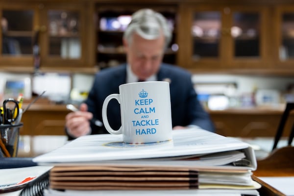 Outgoing FBI Director Christopher Wray works in his office at the J. Edgar Hoover Building in Washington, D.C. on Sunday, January 12, 2025. His coffee mug says “Keep Calm and Tackle Hard.” (Arvin Temkar / AJC)