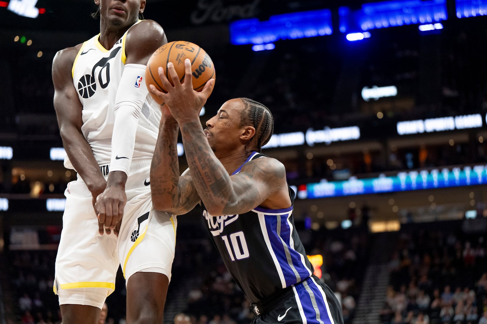 Utah Jazz forward Taylor Hendricks (0) draws the foul charge as Sacramento Kings forward DeMar DeRozan (10) shoots in the first half of an NBA preseason basketball game, Tuesday, Oct. 15, 2024, in Salt Lake City. (AP Photo/Spenser Heaps)