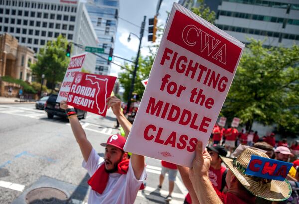 Workers hold signs during a CWA rally outside of AT&T's offices, Saturday, August 3, 2019, in Atlanta.  BRANDEN CAMP/SPECIAL