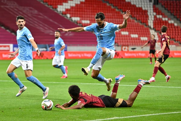 FILE - Belgium's Lois Openda, bottom, in action against Israel's Sagiv Jehezkel, top, during the UEFA Nations League soccer match between Belgium and Israel, at Nagyerdei Stadium, in Debrecen, northeastern Hungary, Friday, Sept. 6, 2024. (AP Photo/Denes Erdos, File)