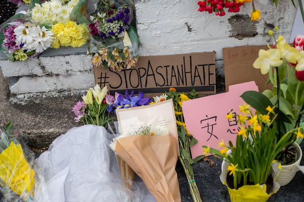 Signs and flowers are displayed outside of the Gold Spa in Atlanta, Friday, March 19, 2021. (Alyssa Pointer / Alyssa.Pointer@ajc.com)