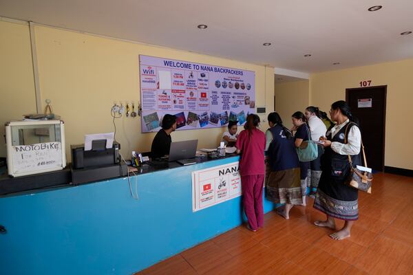 Health officials check documents and ask questions to Nana hostel employees in Vang Vieng, Laos, Friday, Nov. 22, 2024. (AP Photo/Anupam Nath)