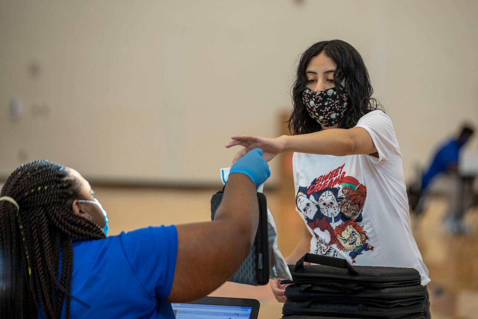 Mundy's Mill High School sophomore Keyla Bustos receives her computer during a laptop distribution at the school in Jonesboro, Georgia on Sept. 1, 2020. (Alyssa Pointer / Alyssa.Pointer@ajc.com)