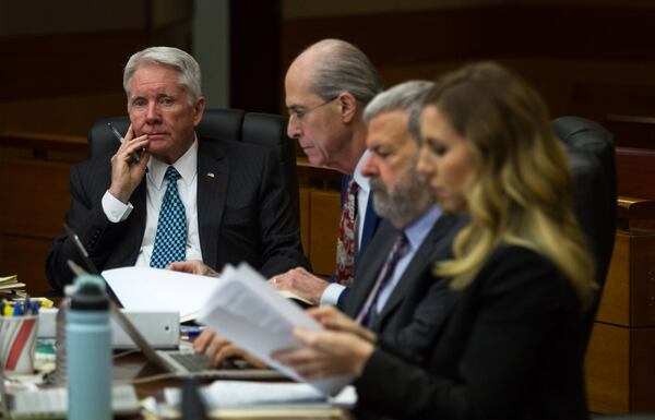 Tex McIver, at far left, listens to the testimony of Jay Grover, a friend of the McIvers and former policeman. STEVE SCHAEFER / SPECIAL TO THE AJC