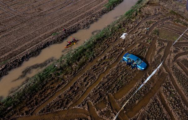 Members of the V battalion of the military emergency unit, UME, use a canoe to search the area for bodies washed away by the floods in the outskirts of Valencia, Spain, Friday, Nov. 8, 2024. (AP Photo/Emilio Morenatti)