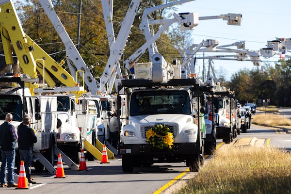 A bucket truck with flowers on the front was driven for a funeral procession in Griffin in honor of lineman Eric Weems on Thursday.