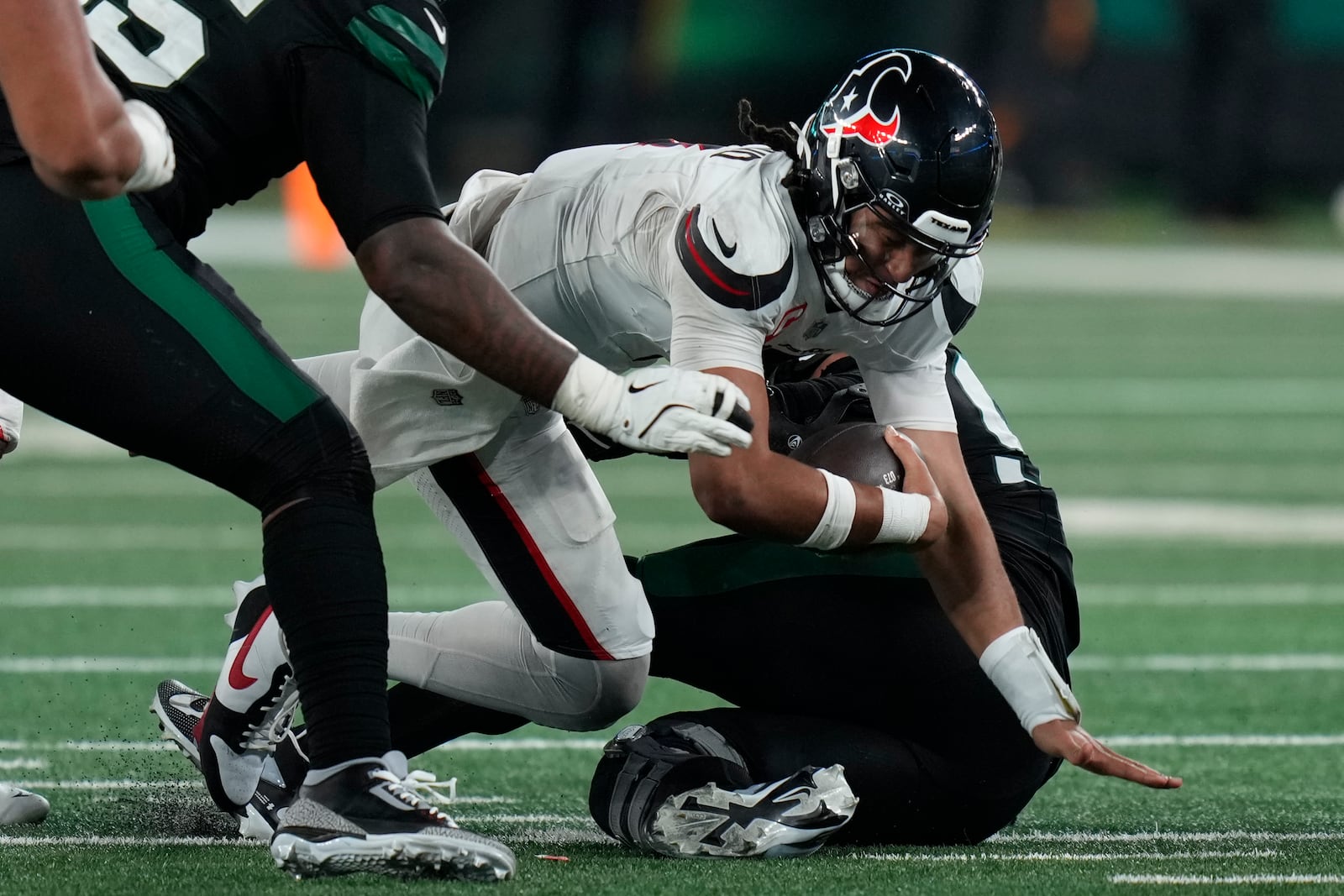 Houston Texans quarterback C.J. Stroud, center, goes down after being sacked by New York Jets defensive end Solomon Thomas, right, during the first half an NFL football game Thursday, Oct. 31, 2024, in East Rutherford, N.J. (AP Photo/Seth Wenig)